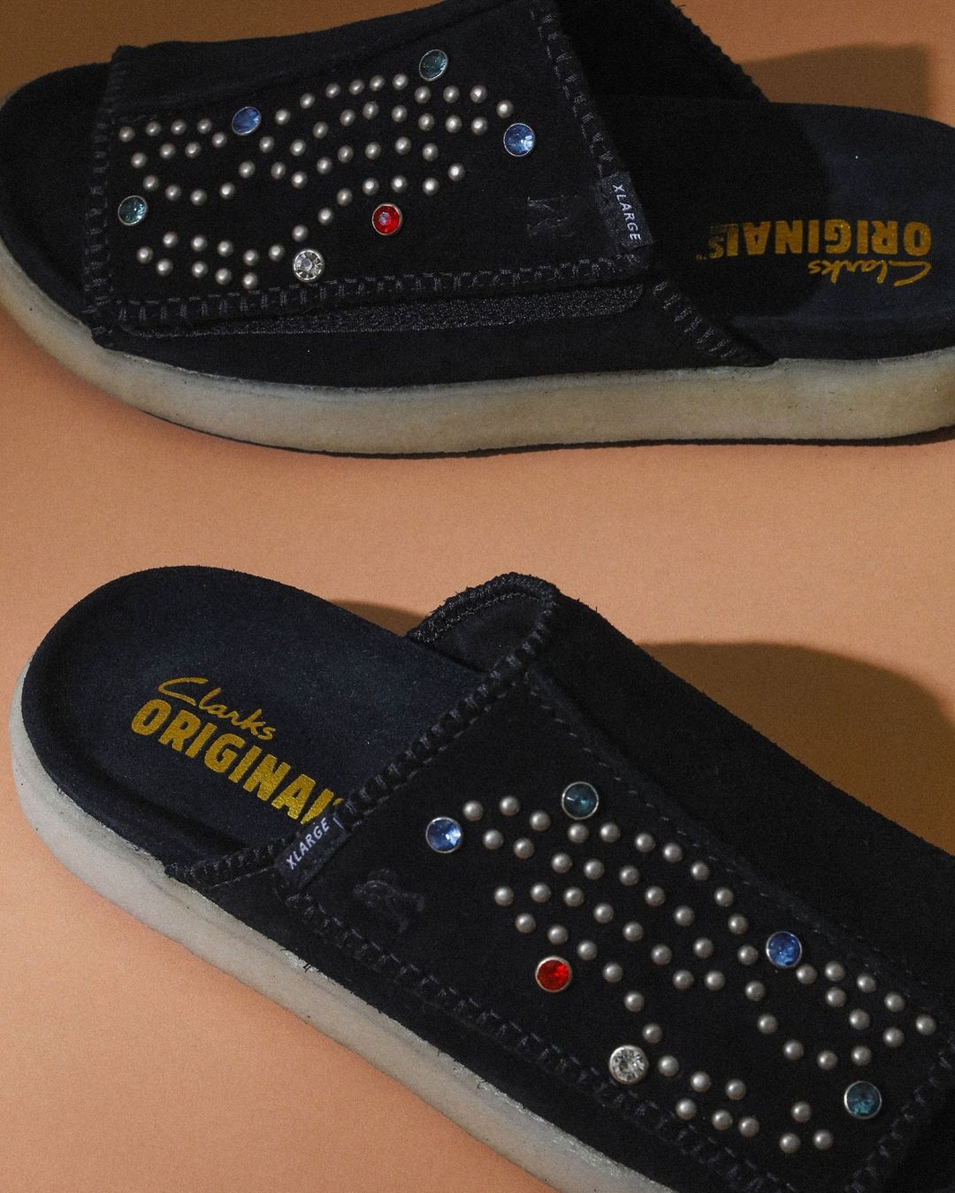 XLARGE × Clarks Originals OVERLEIGH SLIDE 最新コラボが2024年 8/3 発売 ​(エクストララージ クラークス)